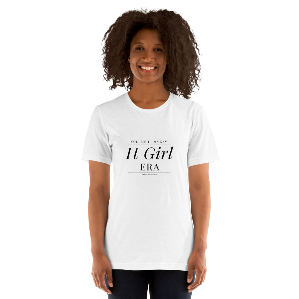 IT GIRL ERA Tee on female model, smiling, white background with plants