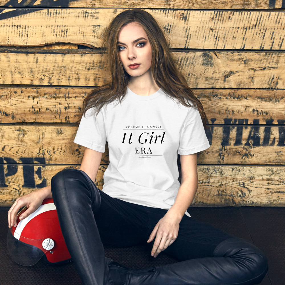 IT GIRL ERA Tee on female model, brunette, editorial wood backdrop